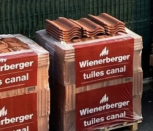 Palettes de tuiles canal neuves livrées sur un chantier de couverture à Fonsorbes